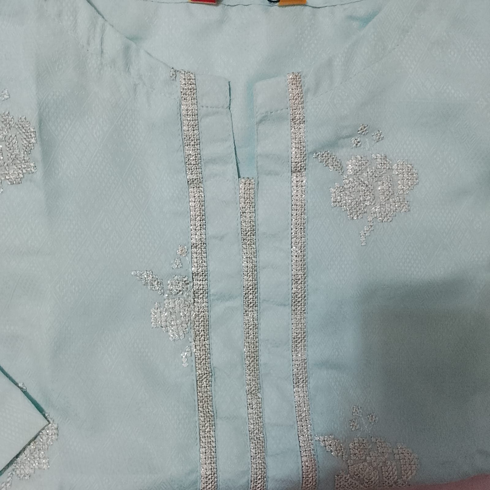 Light blue fabric with intricate silver embroidery